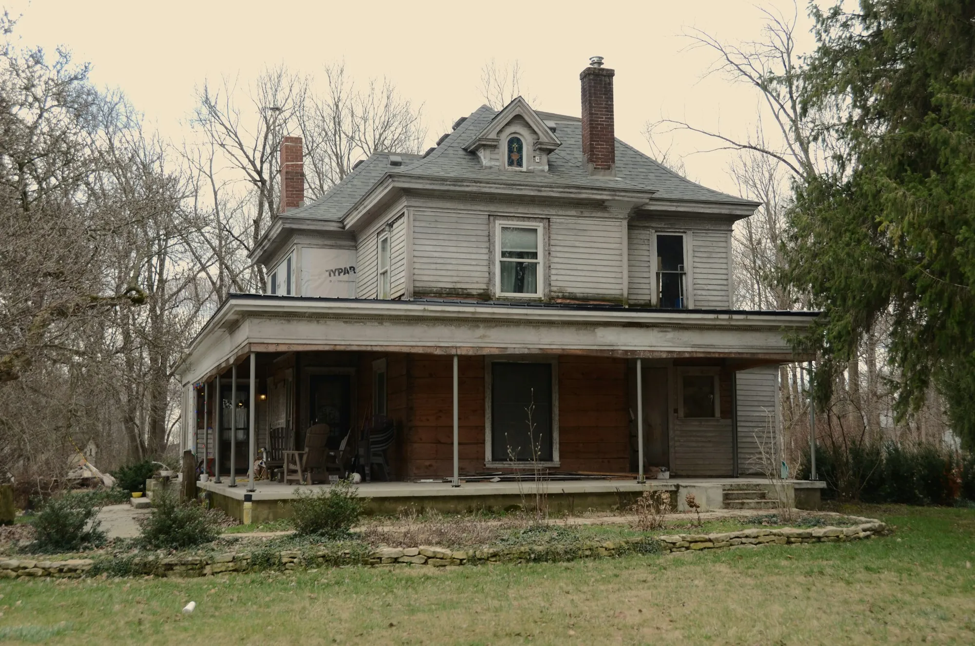 Older two-story house with a wraparound porch