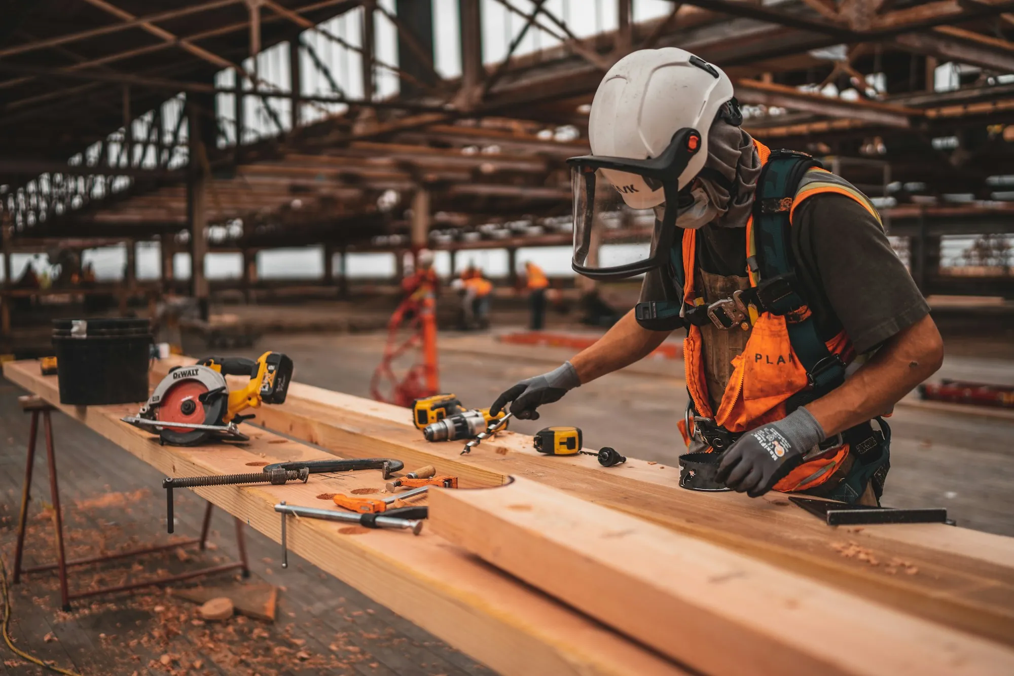 Worker in a respirator cutting material on a workbench